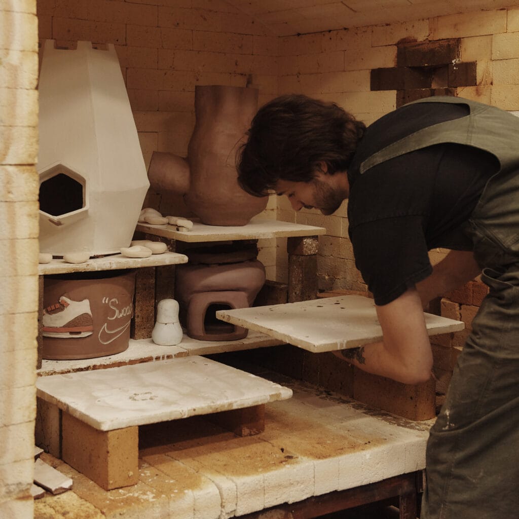 A grad student loading ceramic work into a kiln