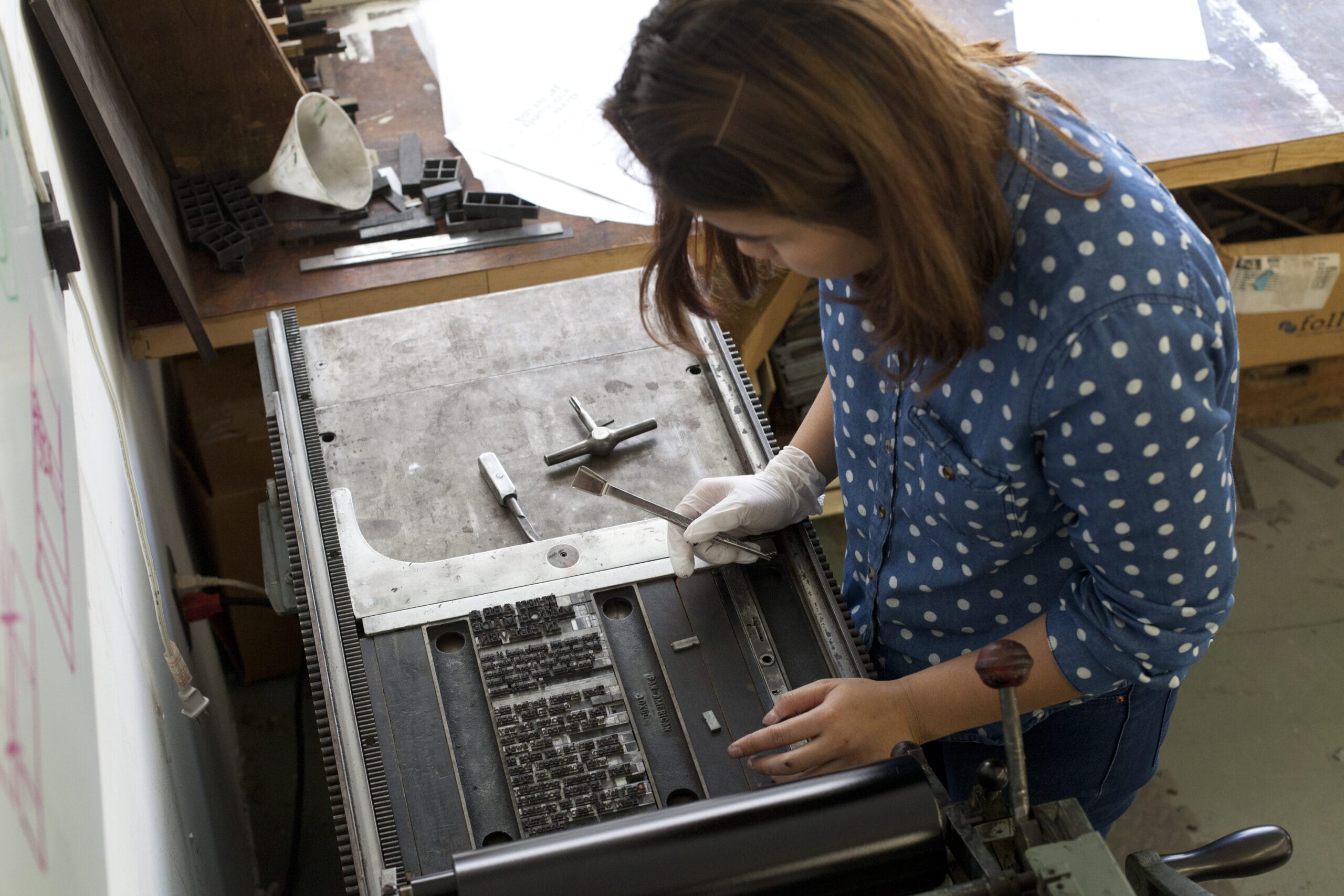 A student looking down at a letterpress