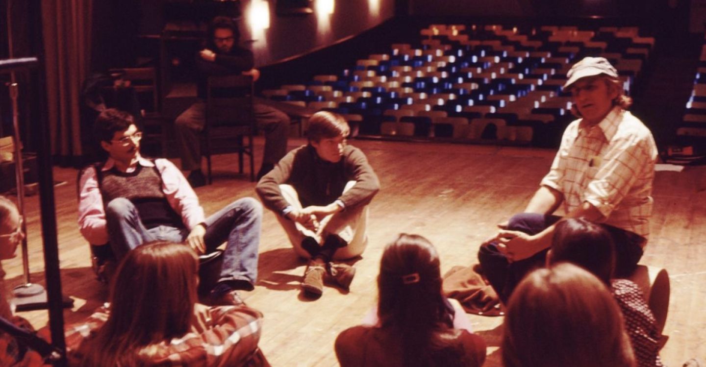 Vintage photo of people sitting on a stage.