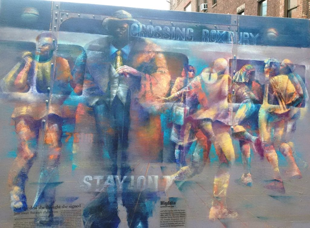 A colorful mural captures a diverse group of people in motion around a central figure holding a drink. The backdrop subtly incorporates train elements with the bold text Roxbury Crossing. The artwork exudes a dynamic, abstract style.