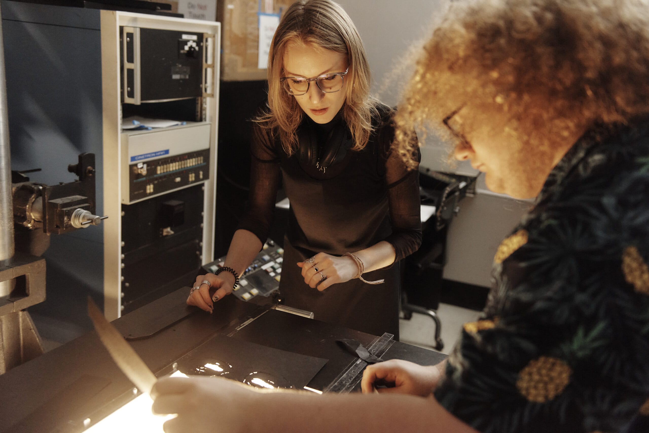 2 people stare down at a light table in the Animation department