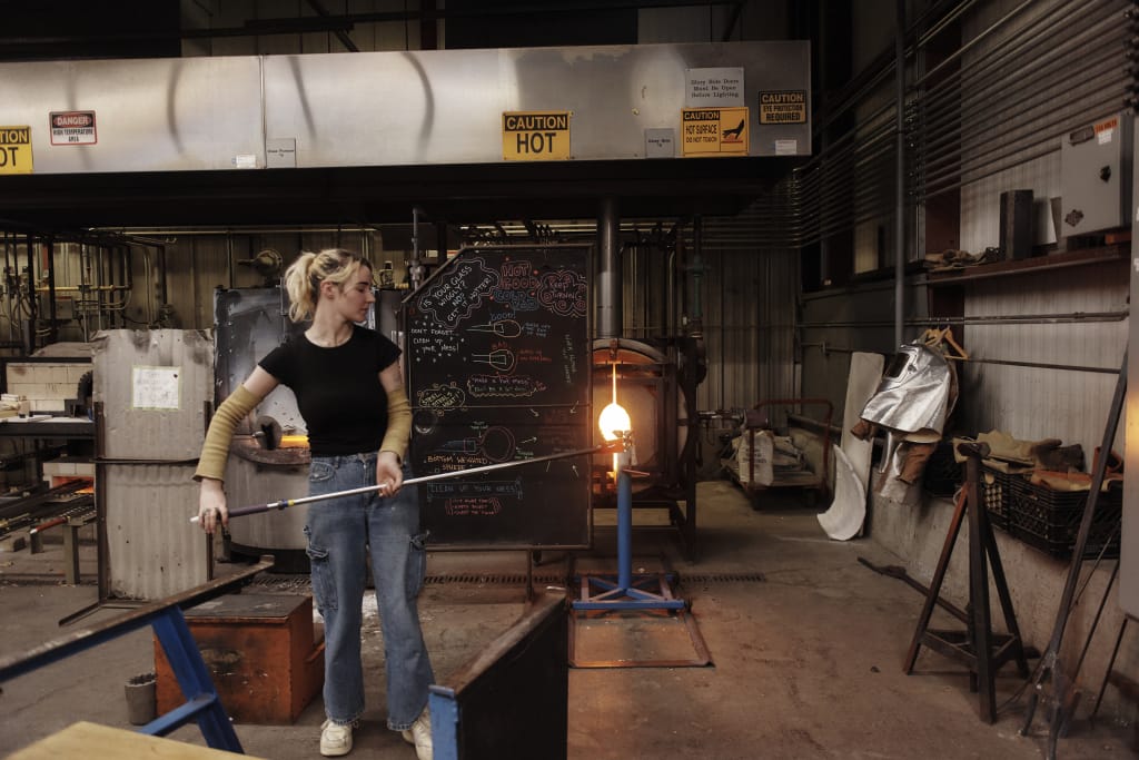 A student glassblowing in the hot shop at MassArt.
