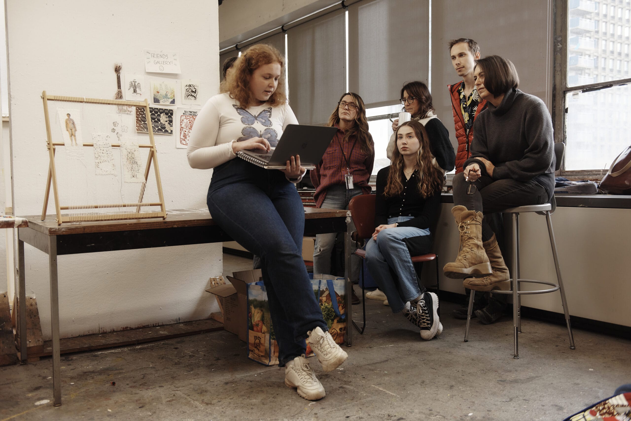 A student looks at her laptop while presenting in a graduate level critique