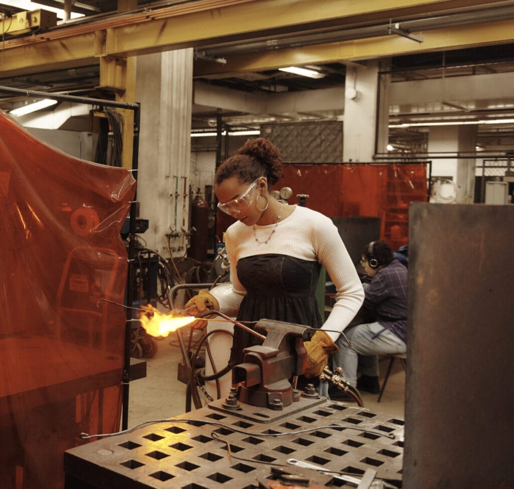 A student working with a blow torch in the Metal Shop