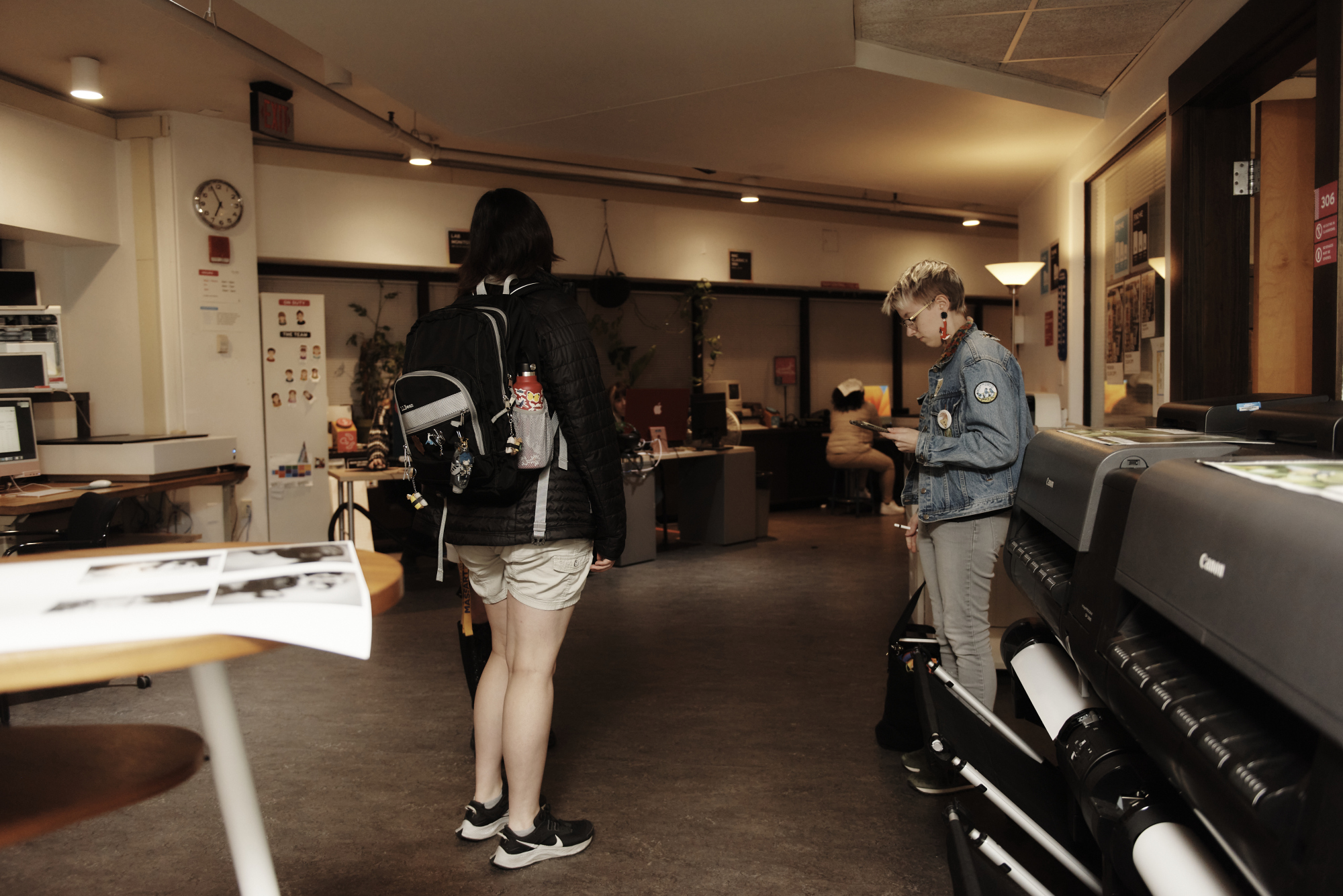 Students stand around waiting for friends in the 3rd Floor print lab