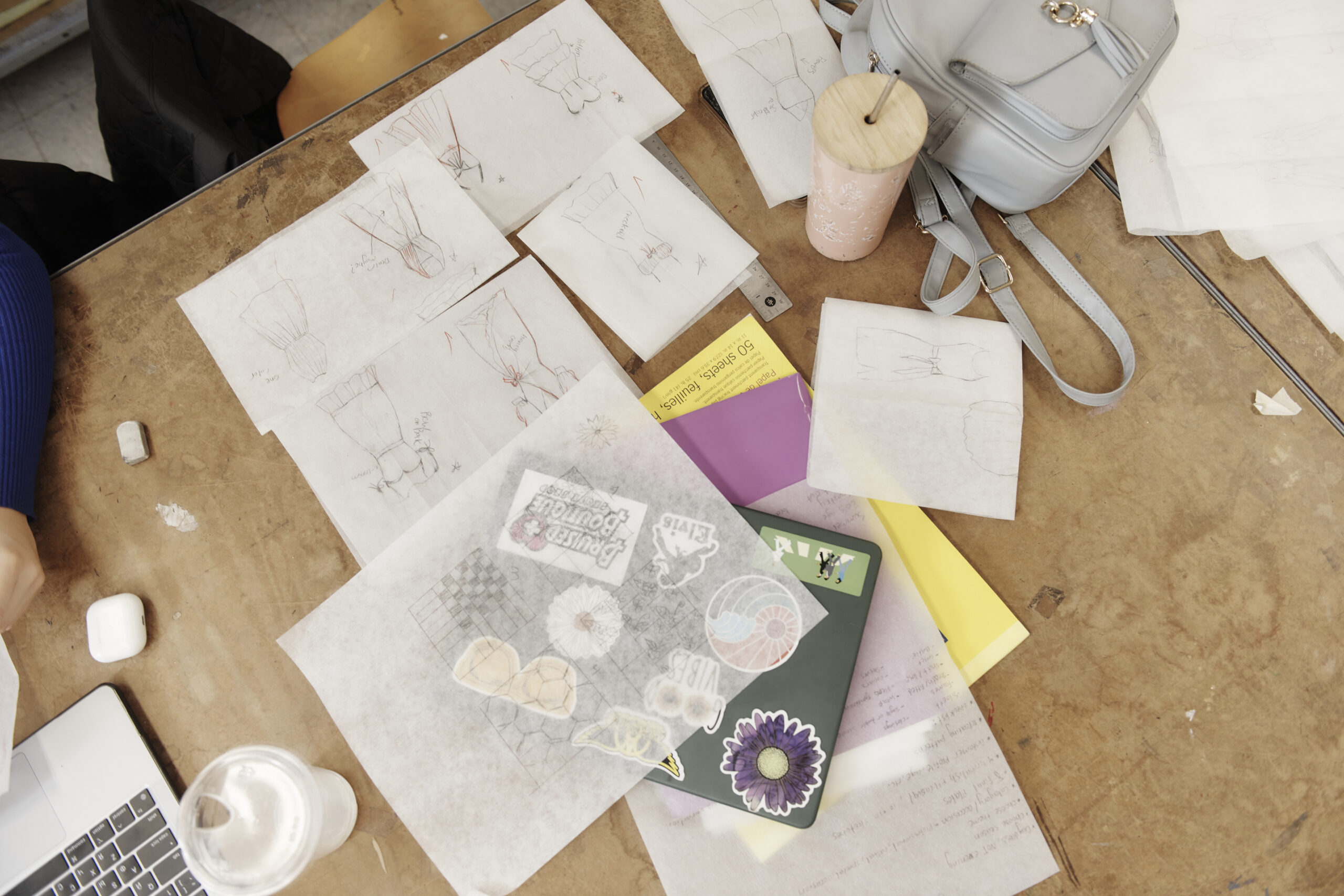 Fashion Design sketches spread out on a table.