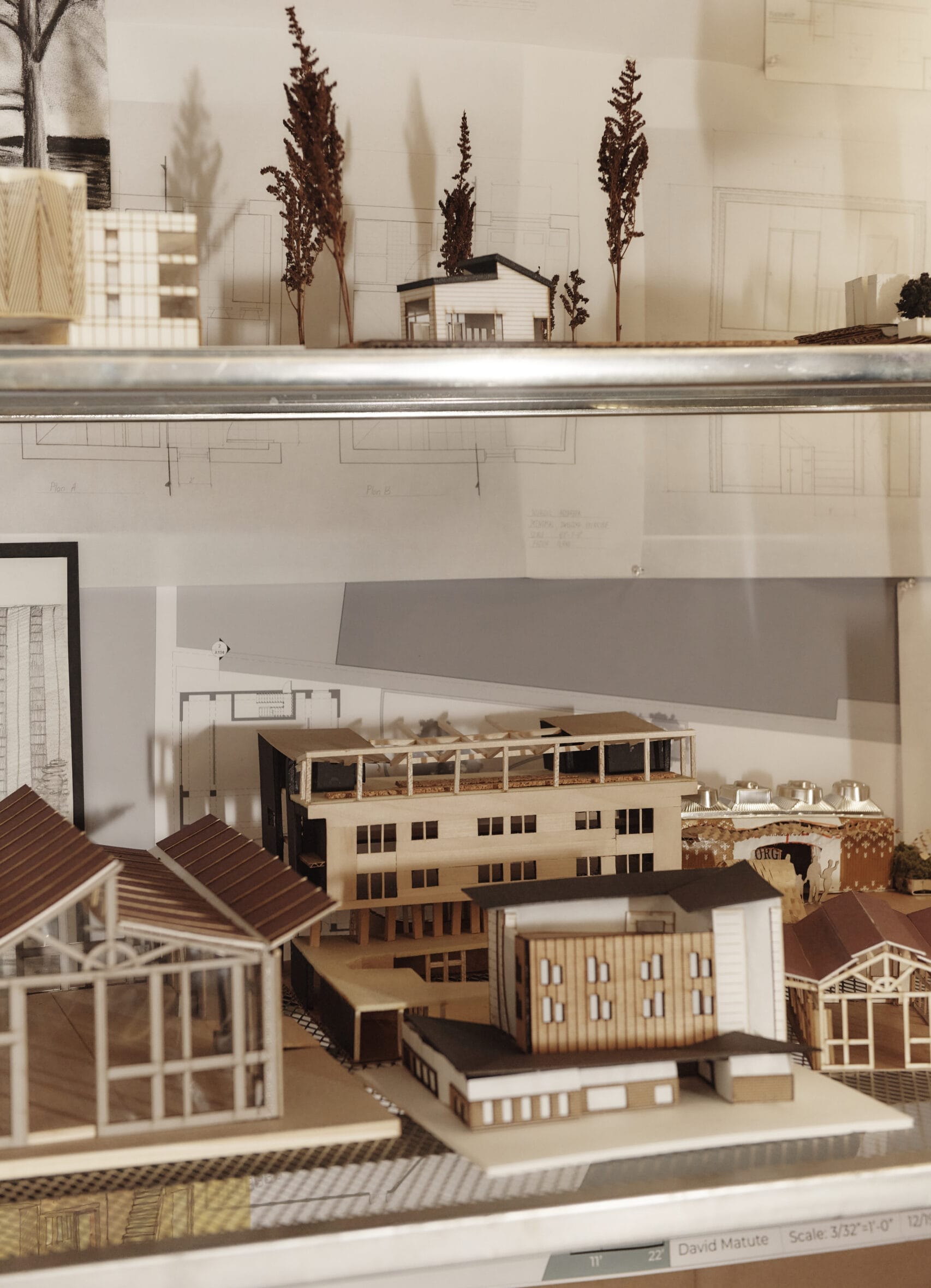 Lots of Architectural models made of wood lined up on shelves.