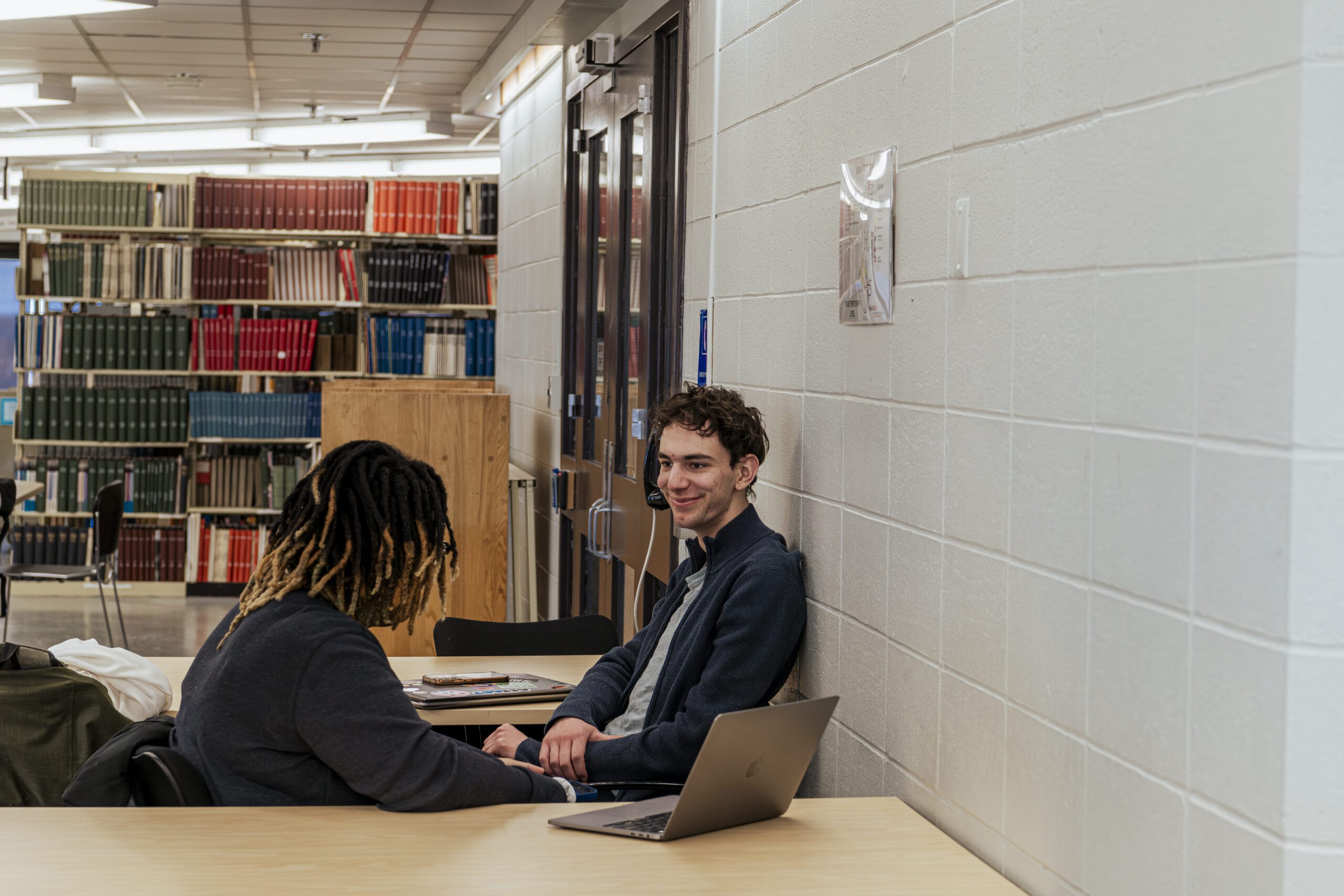 Two students conversing in the Morton R. Godine Library at MassArt.