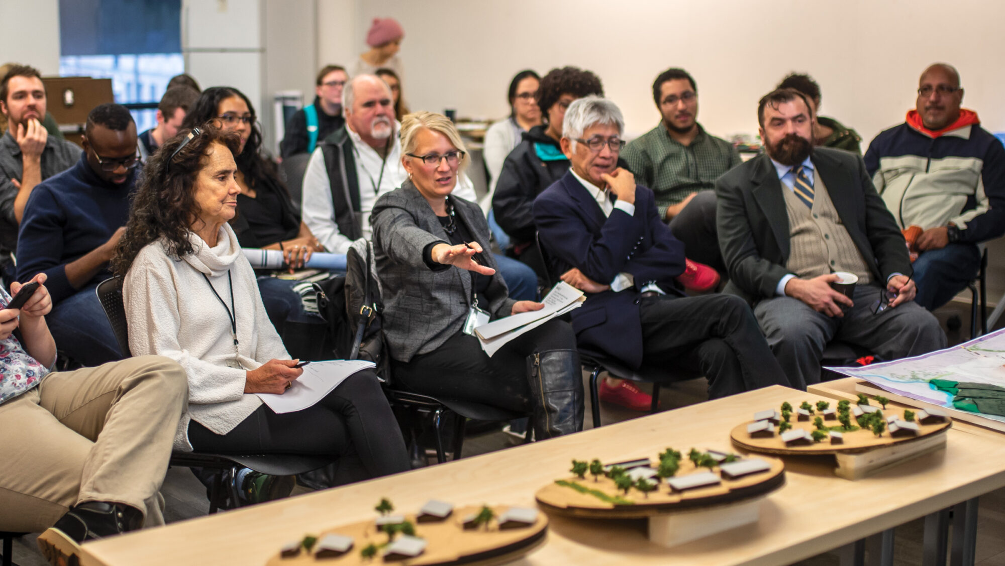 Architecture professionals sitting and facing a table of projects.