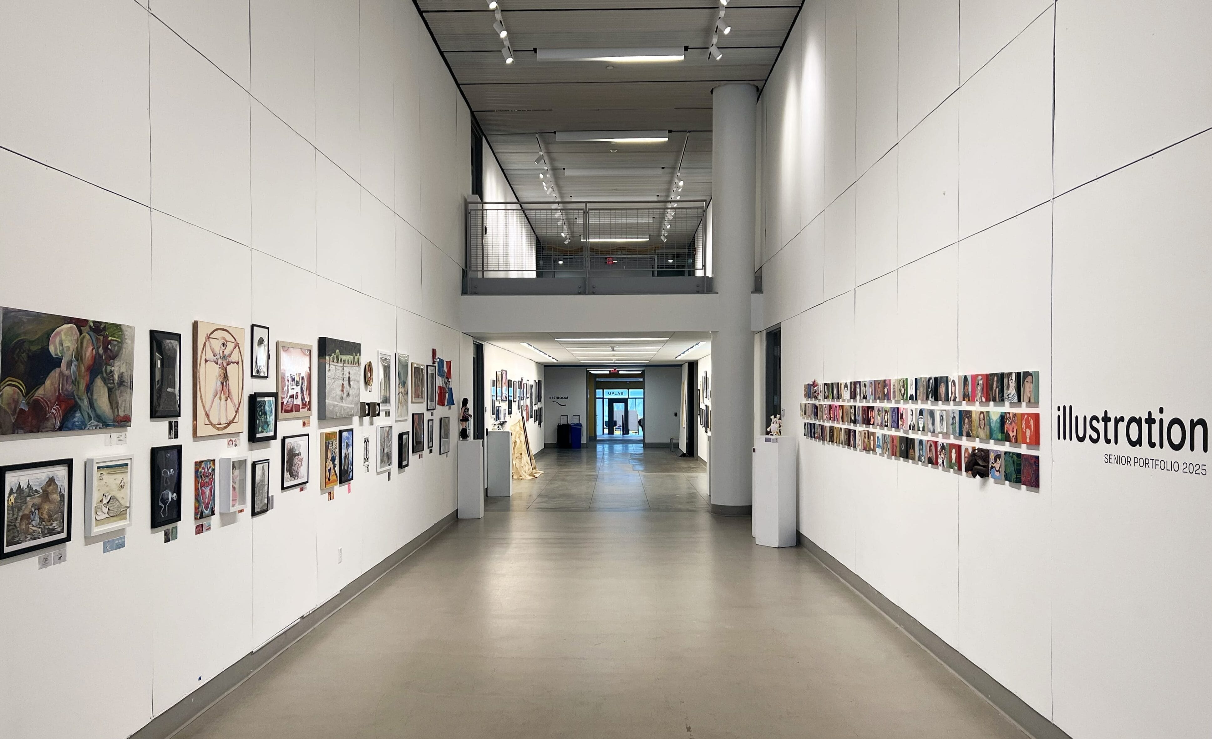 A spacious art gallery hallway displays colorful illustrations and artworks on white walls, with Senior Illustration Thesis 2023 written on the right wall and a bright entrance visible at the far end.