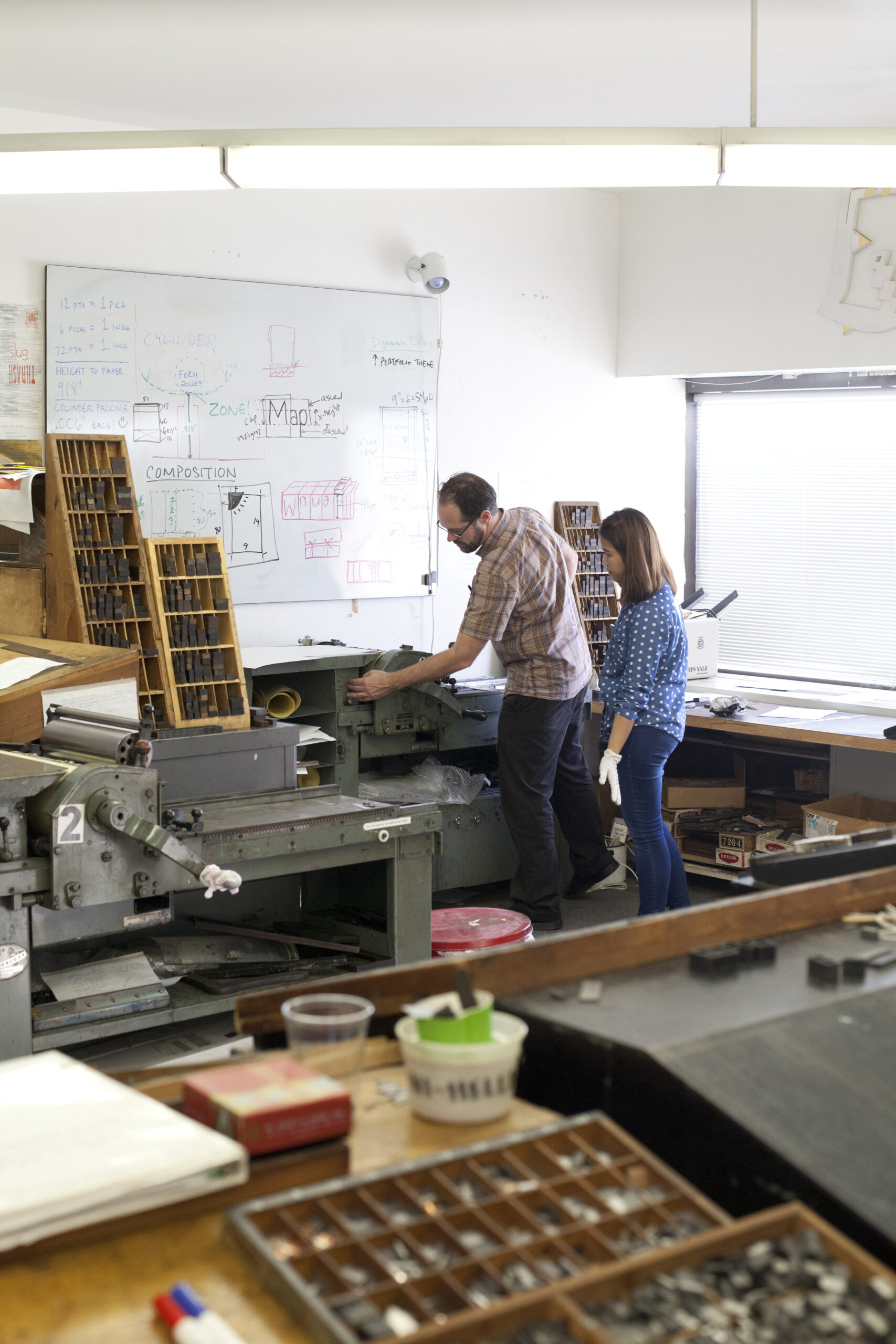 Two people working in MassArt's Letterpress Studio