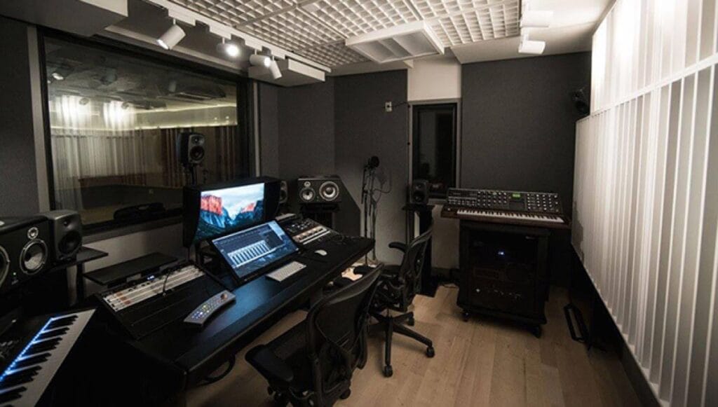 A sound proof recording room with computers and sound boards.