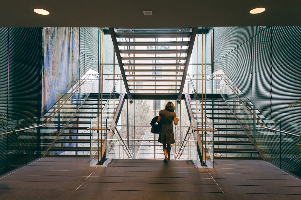 A person walks down the middle of a stairwell.