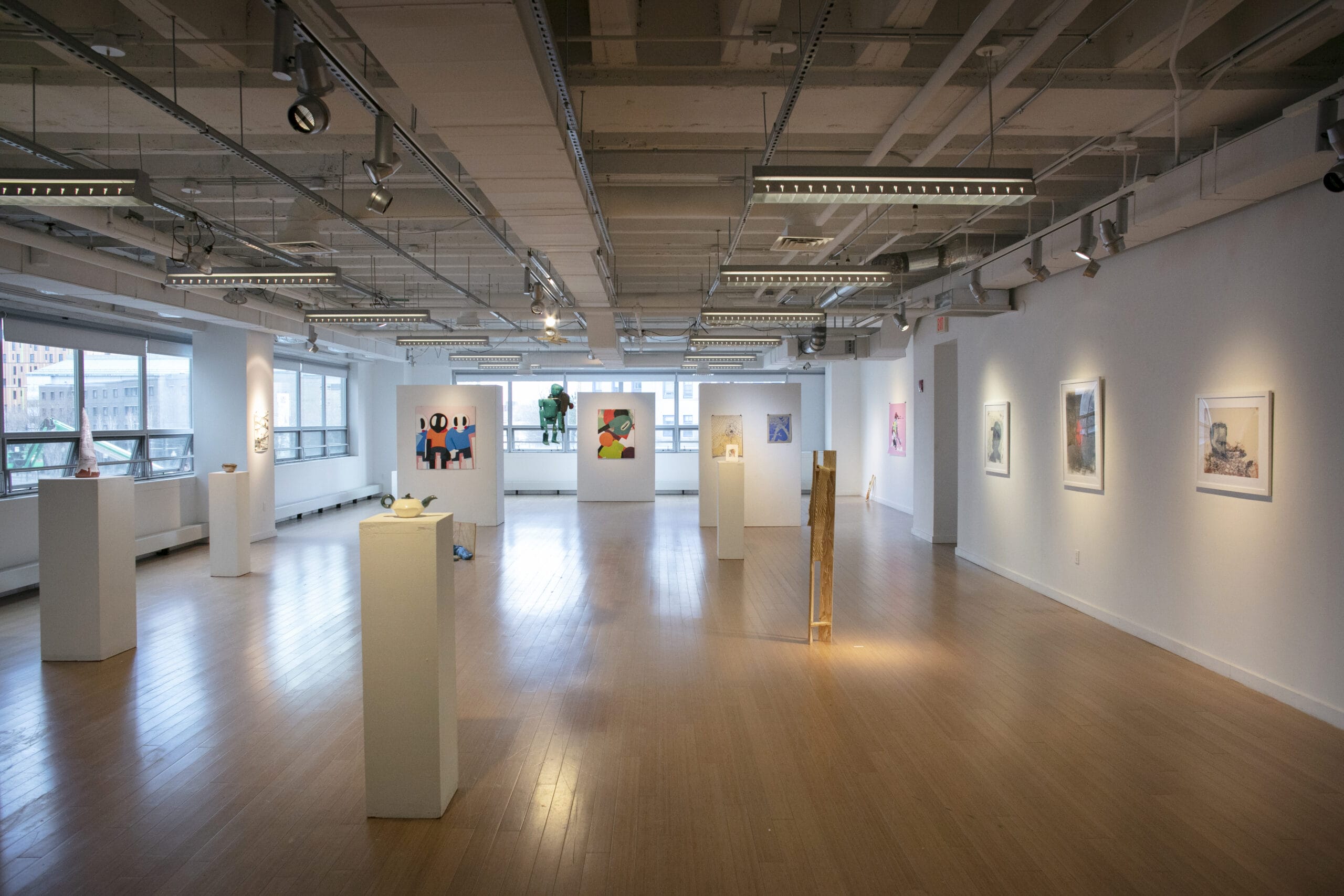 A large gallery with pedestals and artwork.