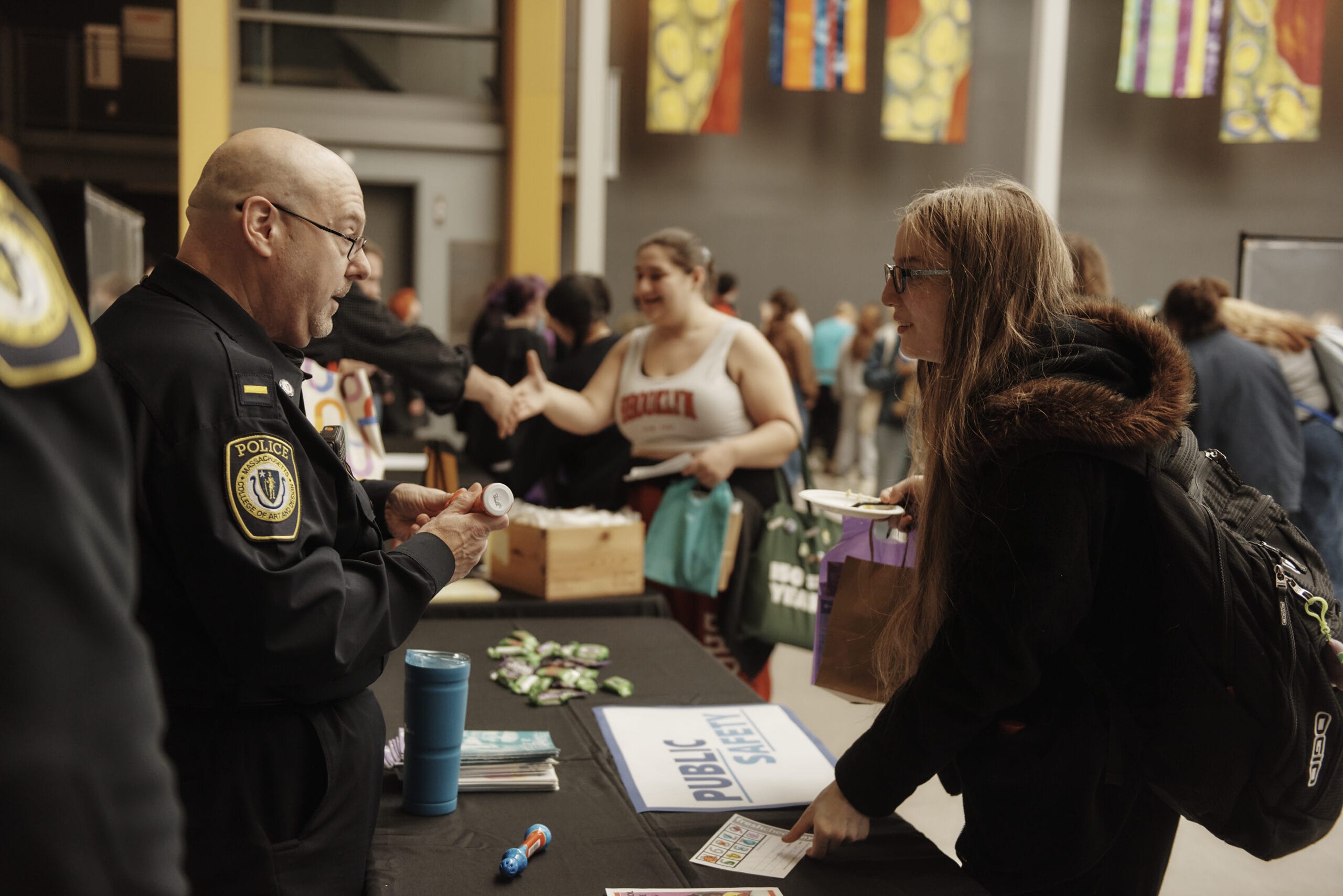 A Public Safety police officer speaks to a student at a community health & wellness fair in the Design and Media Center.