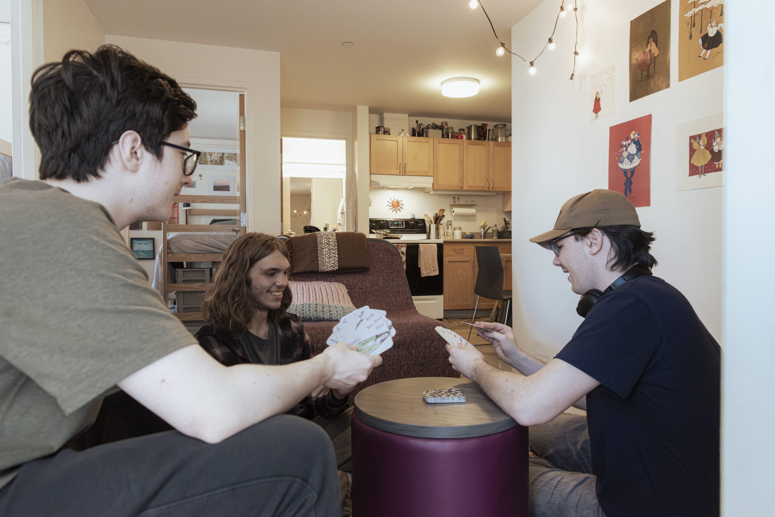 3 students shown sitting around in a living area