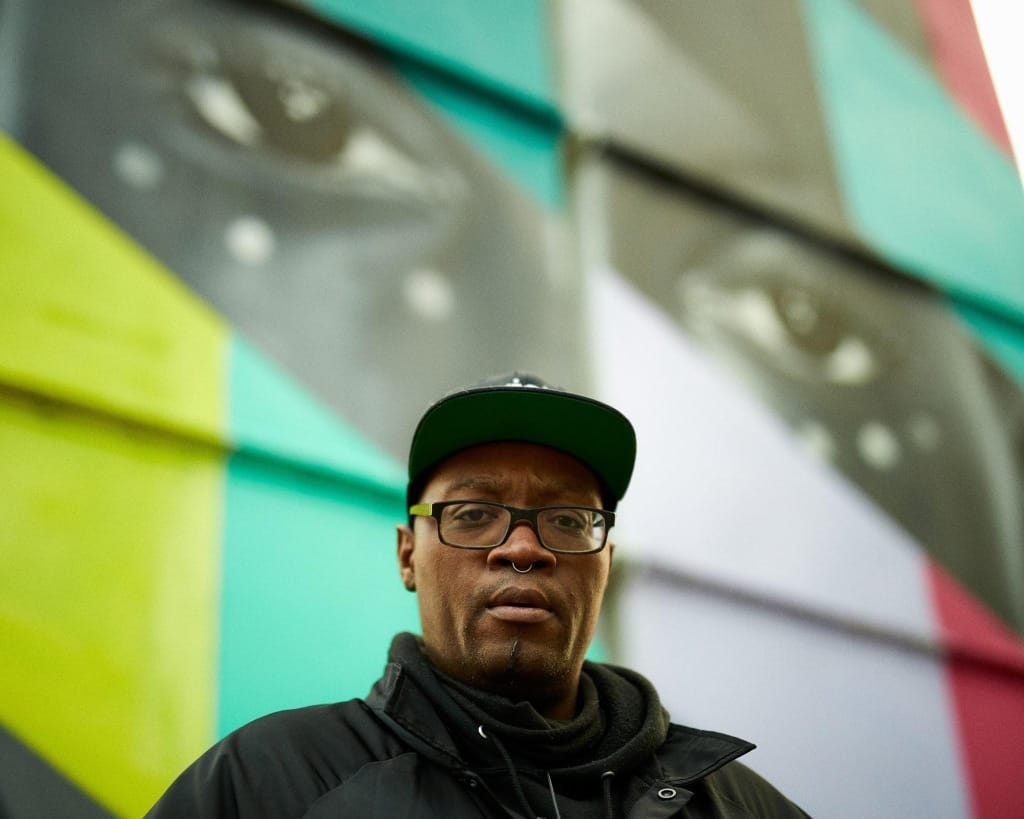 Photo of Cedric Douglas in front of a colorful mural