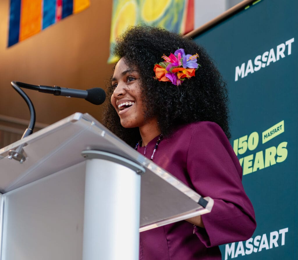 A student stands at a podium smiling