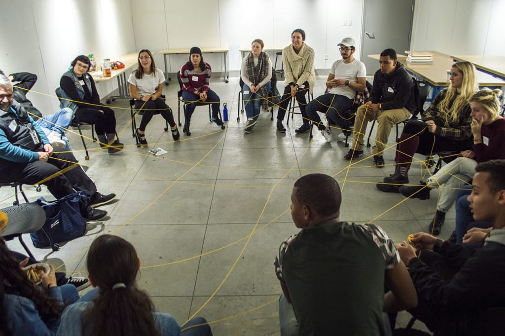 People sitting in a circle, connected by string