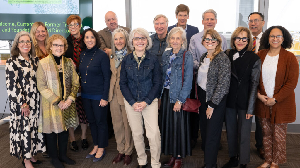 MassArt's President Grant and her Board of Trustees stand together smiling for a group photo.