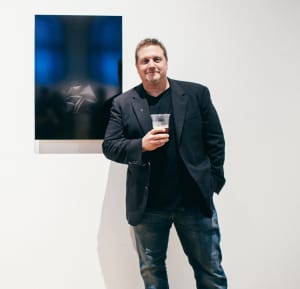 Marc Holland standing in front of an artwork.