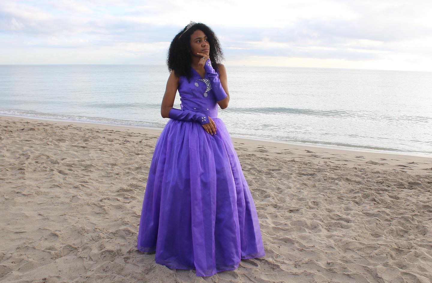Heily Rivas stands on a beach wearing a purple Quinceañera dress. Photo: Harol Rivas