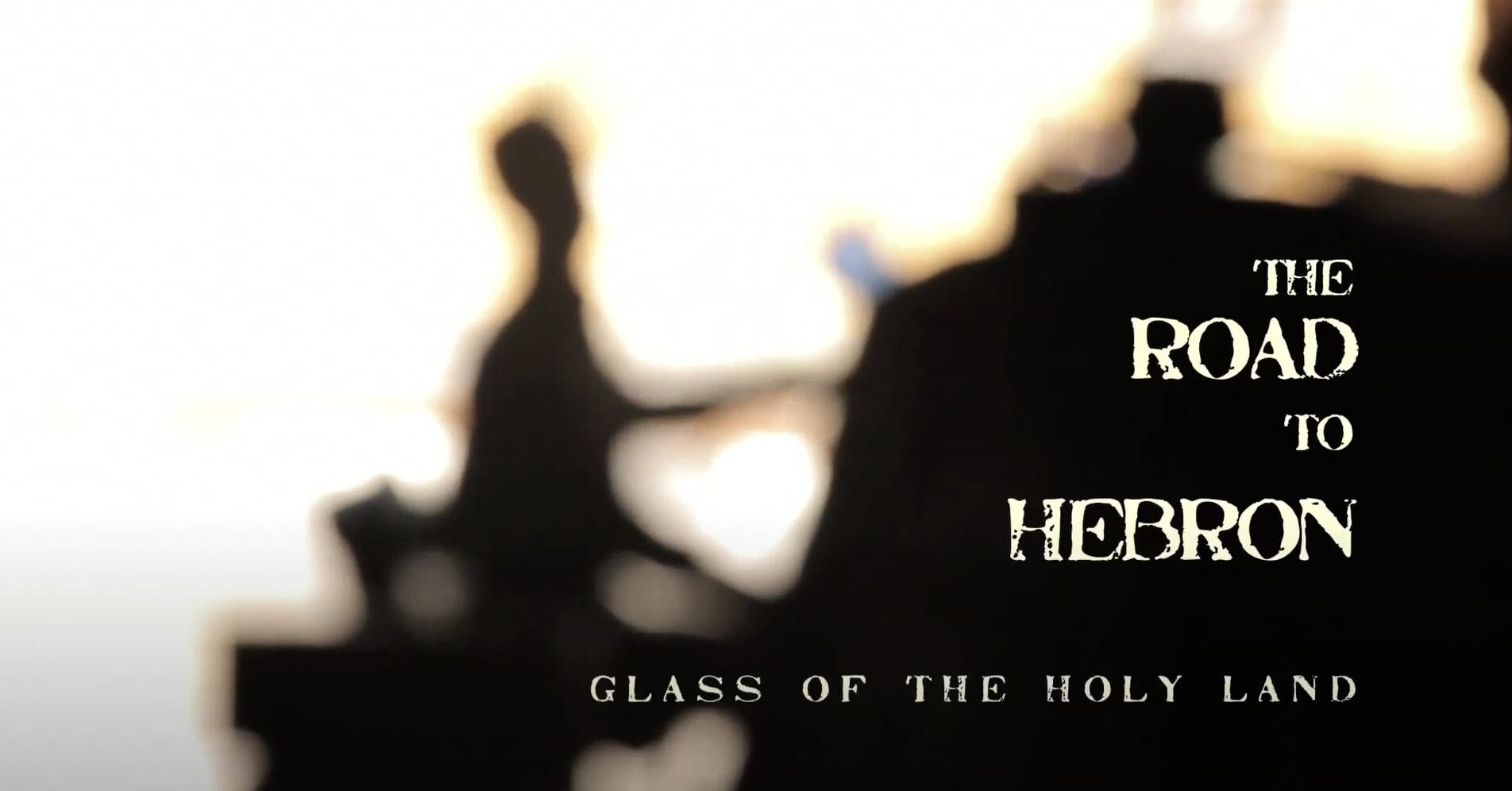 Screen shot from The Road to Hebron film showing the title in print over a black fuzzy silhouette of a person.