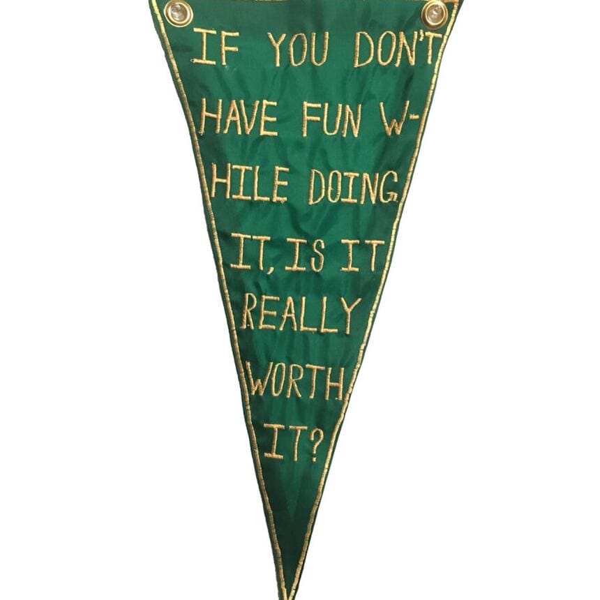 A green, handmade pennant that says "If you don't have fun while doing it, is it really worth it?"