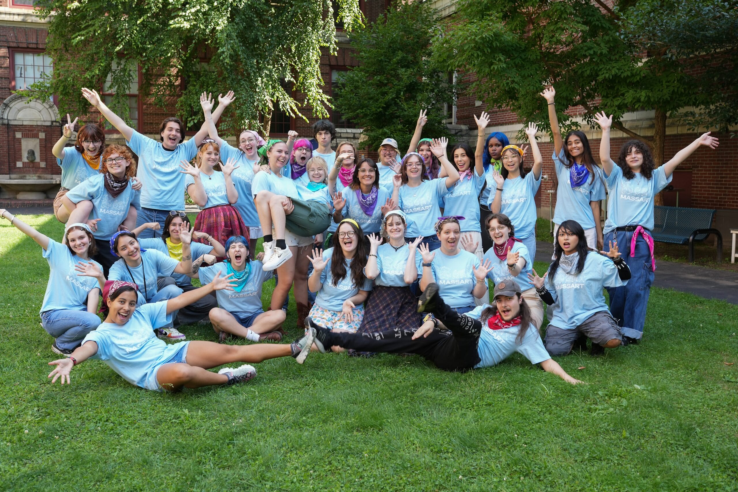 MassArt's Orientation Primers smiling in a group photo on the lawn in MassArt's Courtyard.