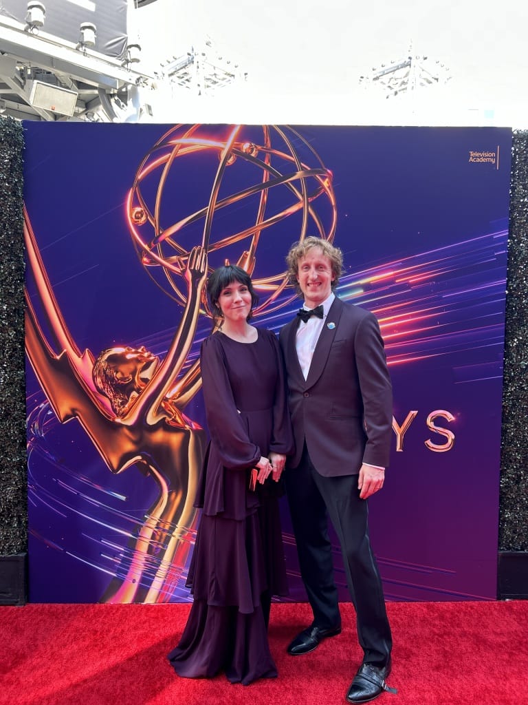 Lindsay and Alex Small-Butera dressed in formal clothing on the red carpet at the 2024 Emmy Awards.