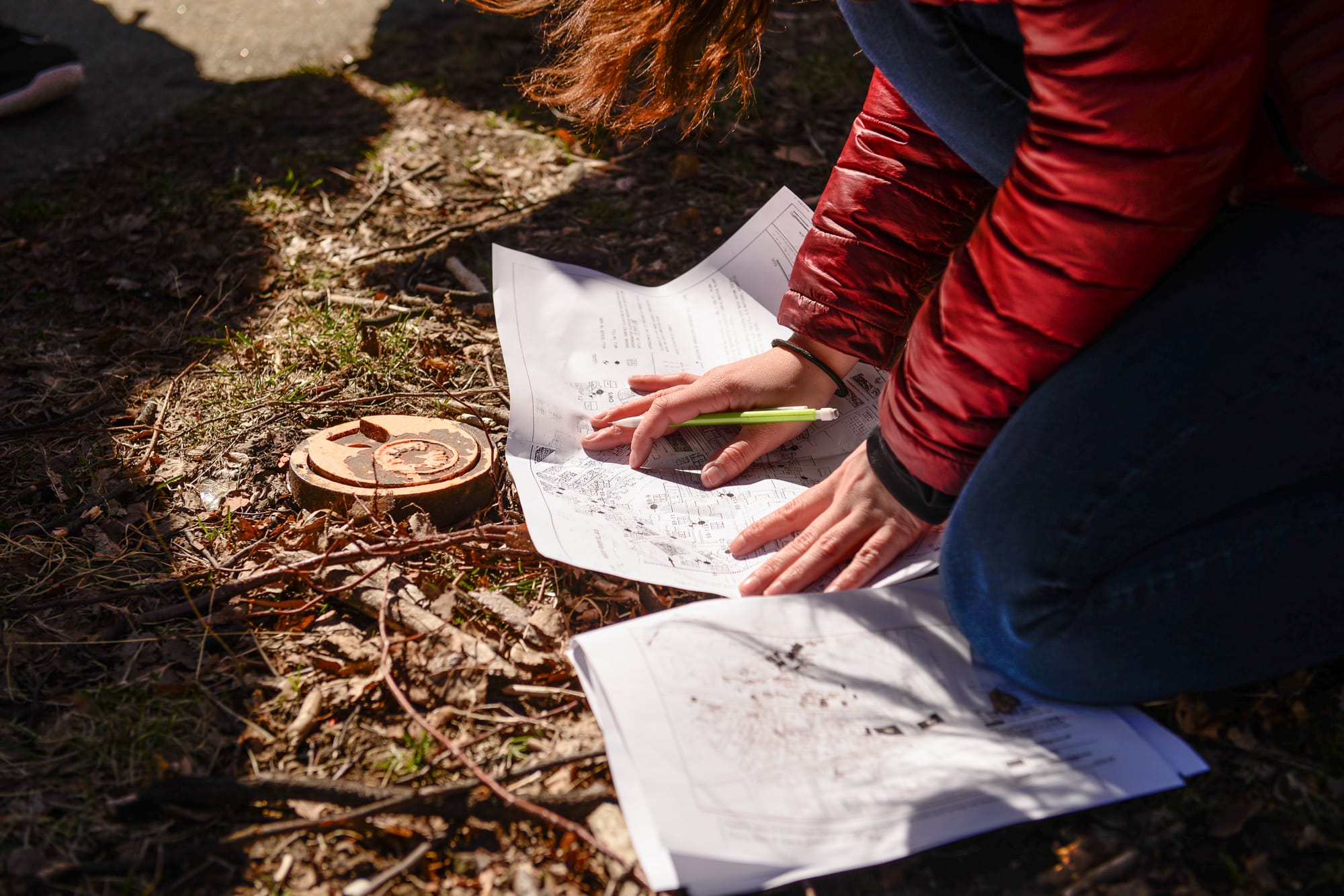 A person carefully looking at a topographical drawing on the ground.