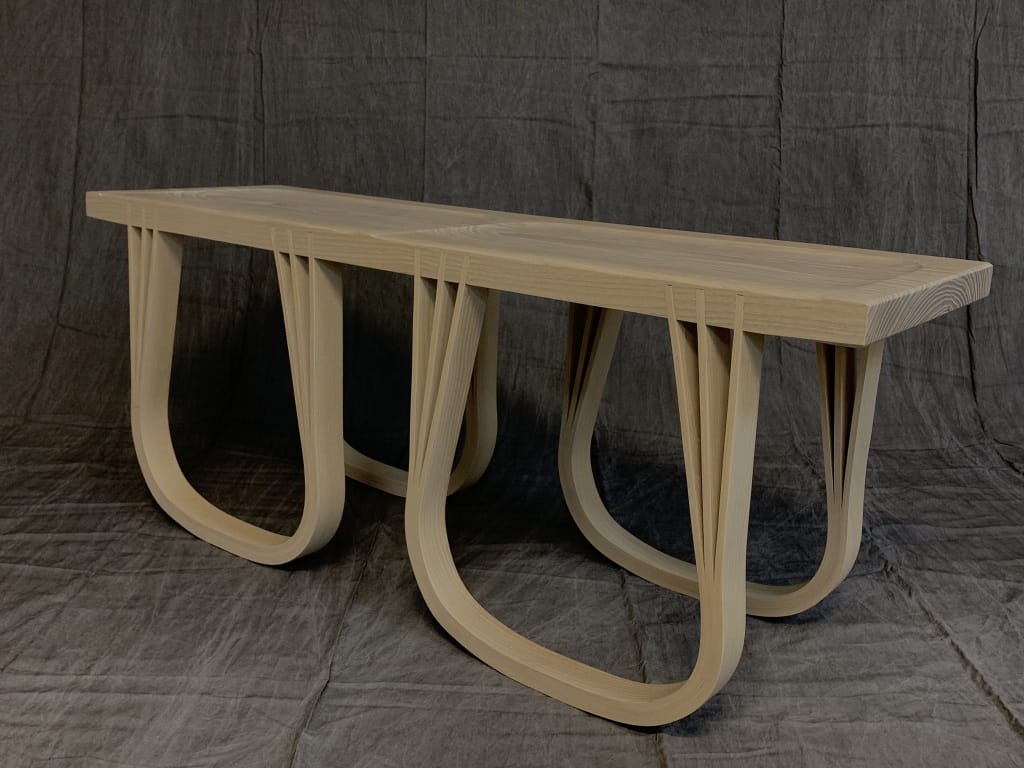 A wooden bench with curved legs