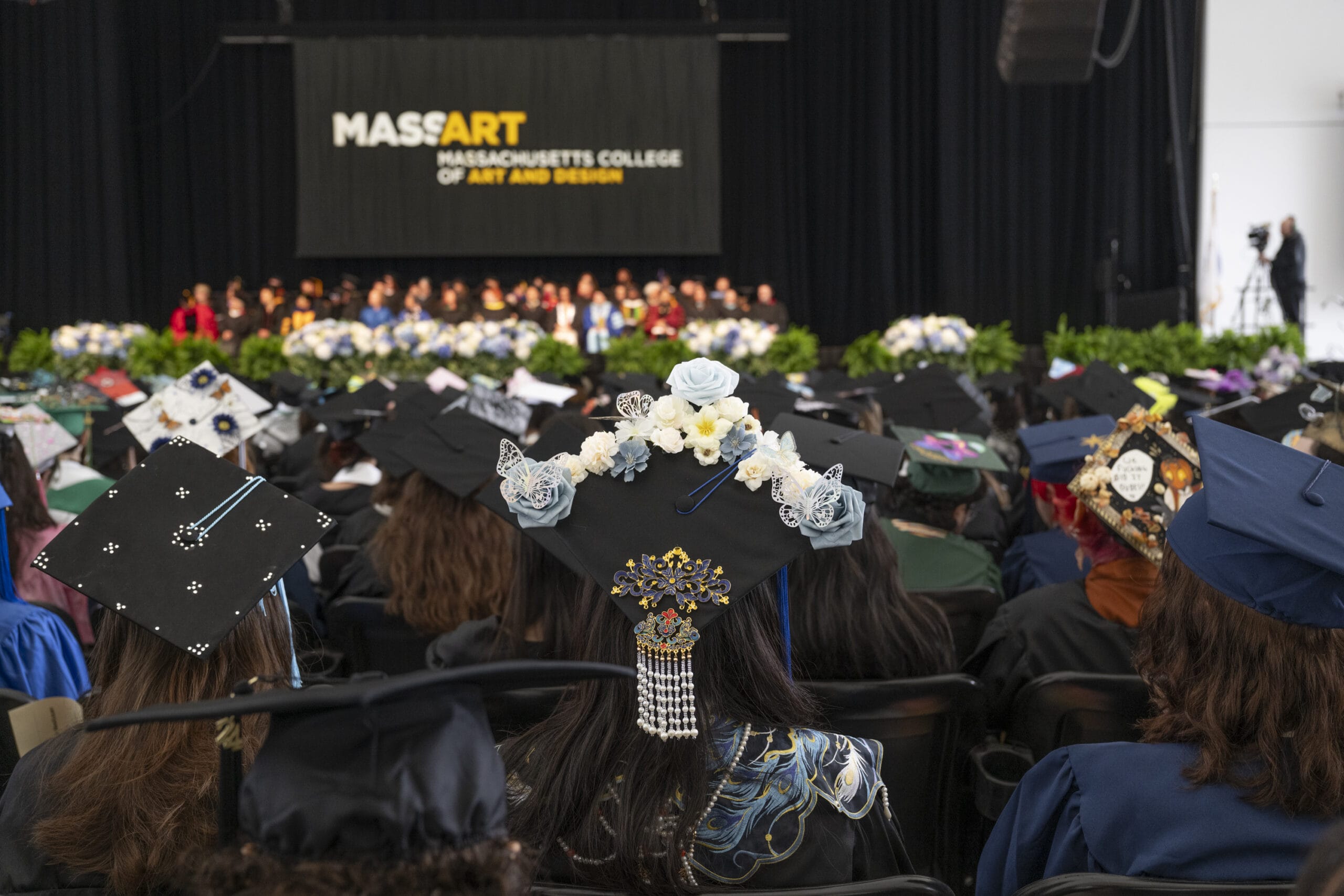 View of the MassArt Commencement Ceremony and the tops of graduates caps.