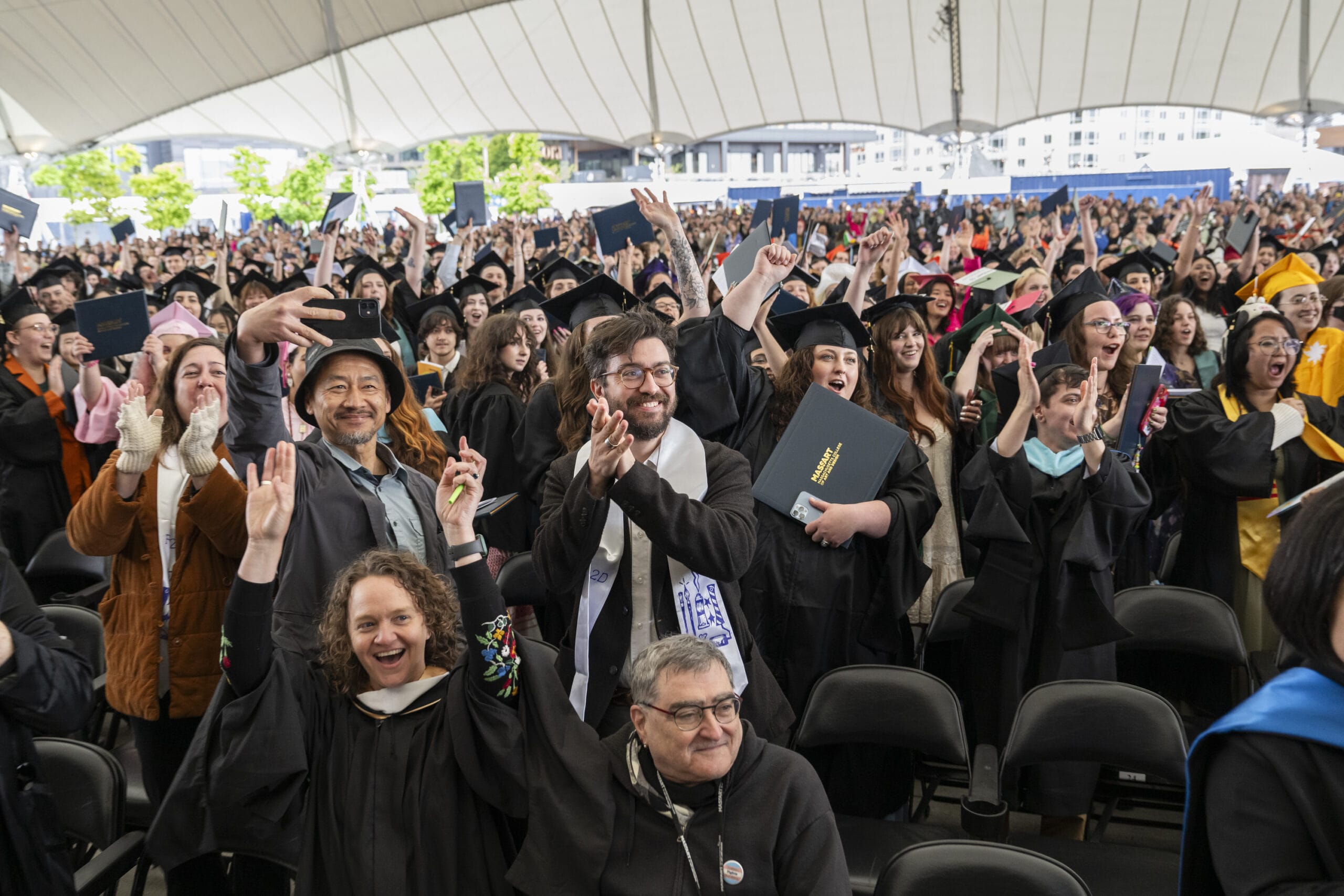 Professors and guests cheer for MassArt's graduates.