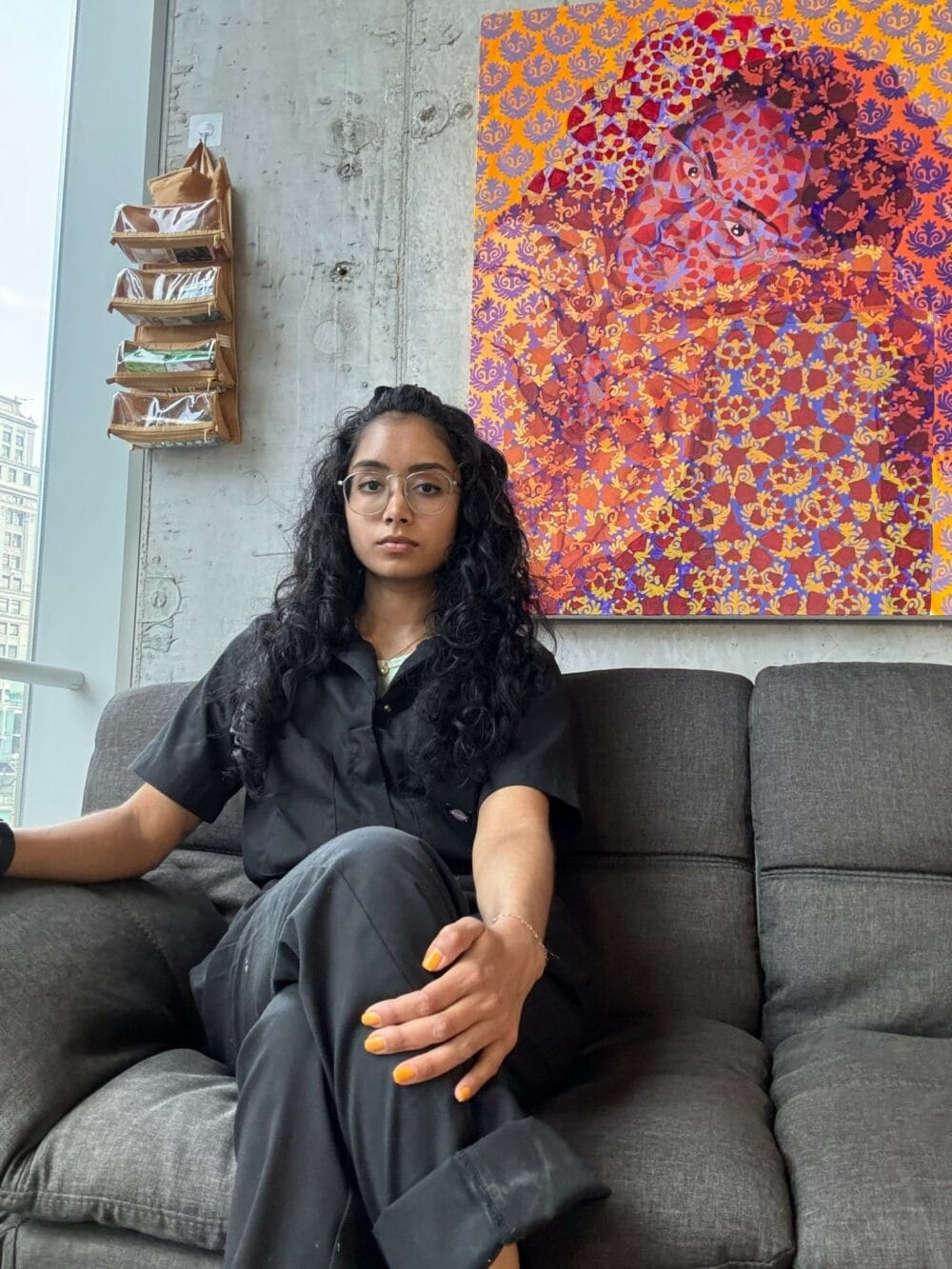 Artist sitting on couch in front of painting