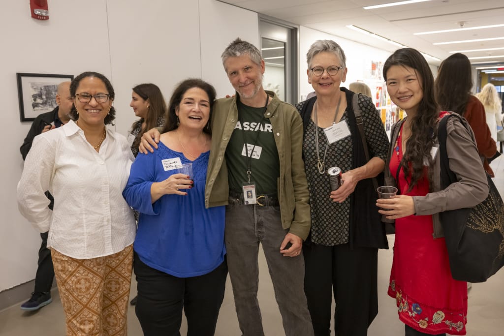MassArt Staff and Alumni standing together, smiling at the camera an art gallery reception.