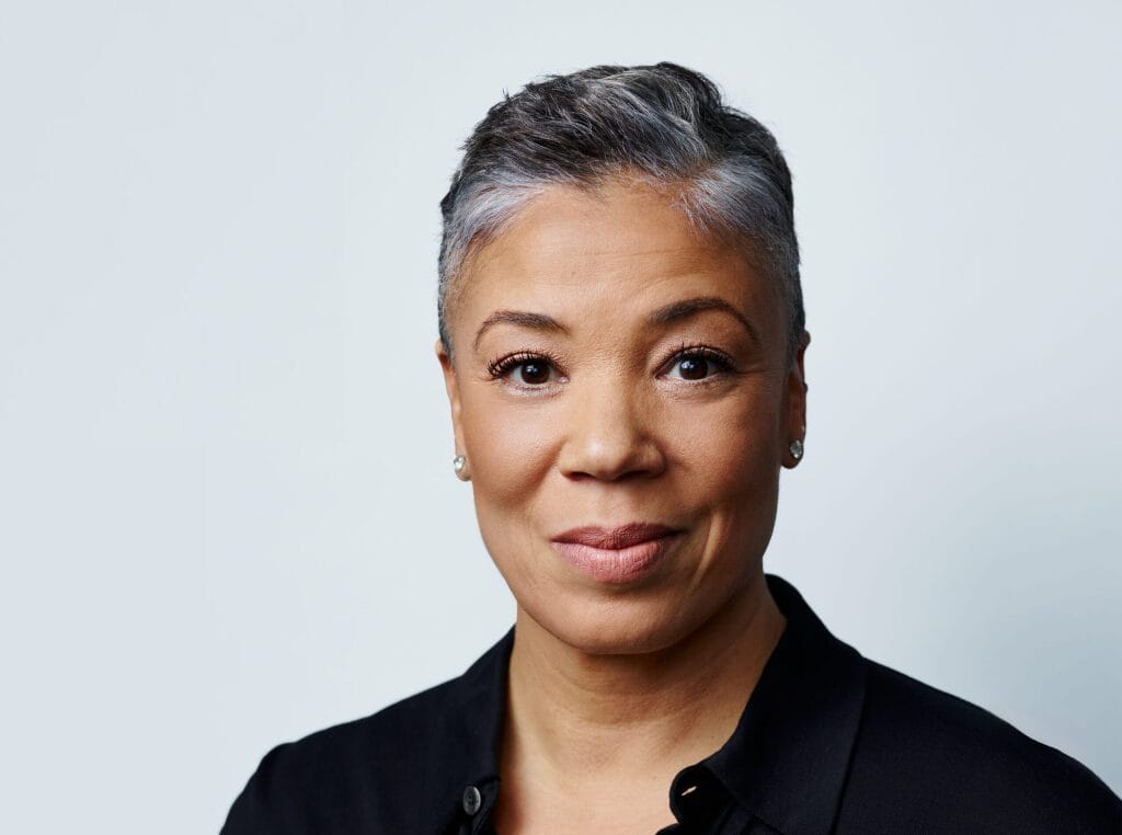 Headshot of woman against grey background.