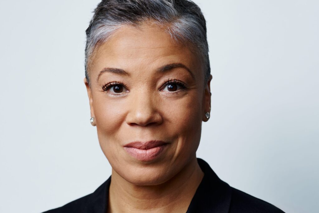 Headshot of woman against grey background.