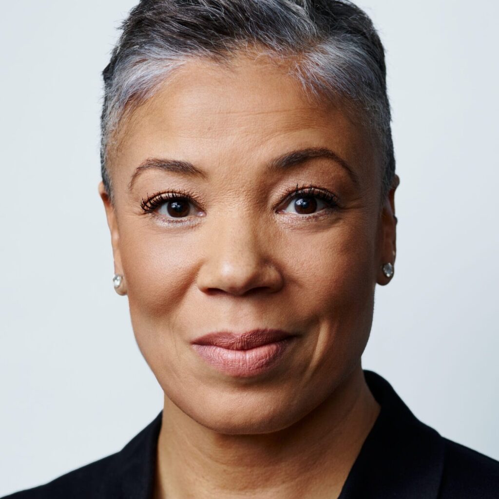 Headshot of woman against grey background.