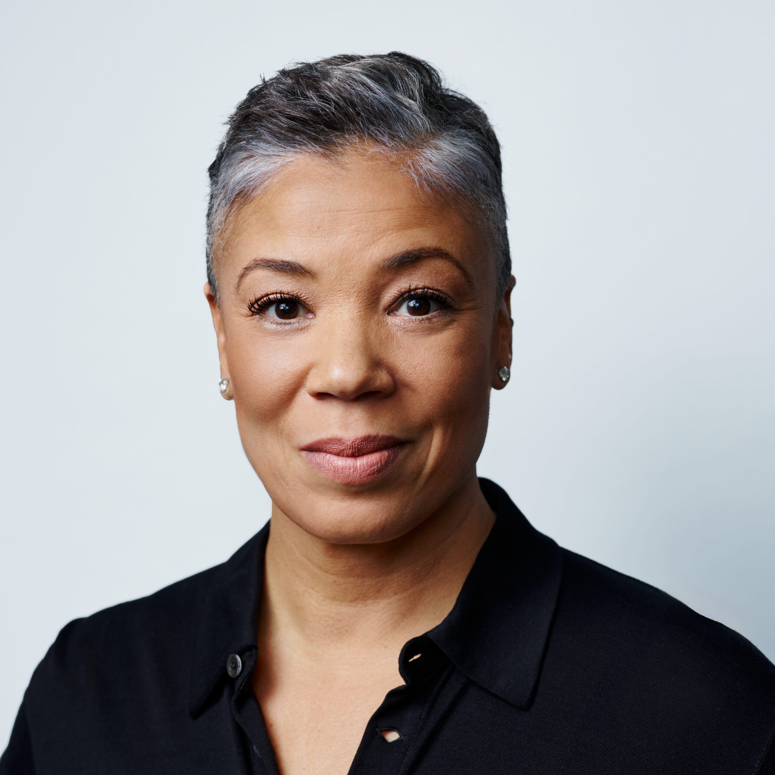 Headshot of woman against grey background.