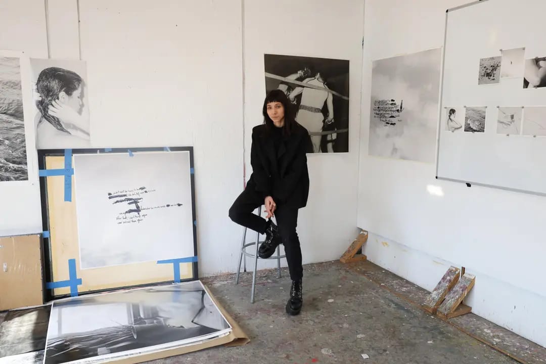 Woman sitting on stool with artwork