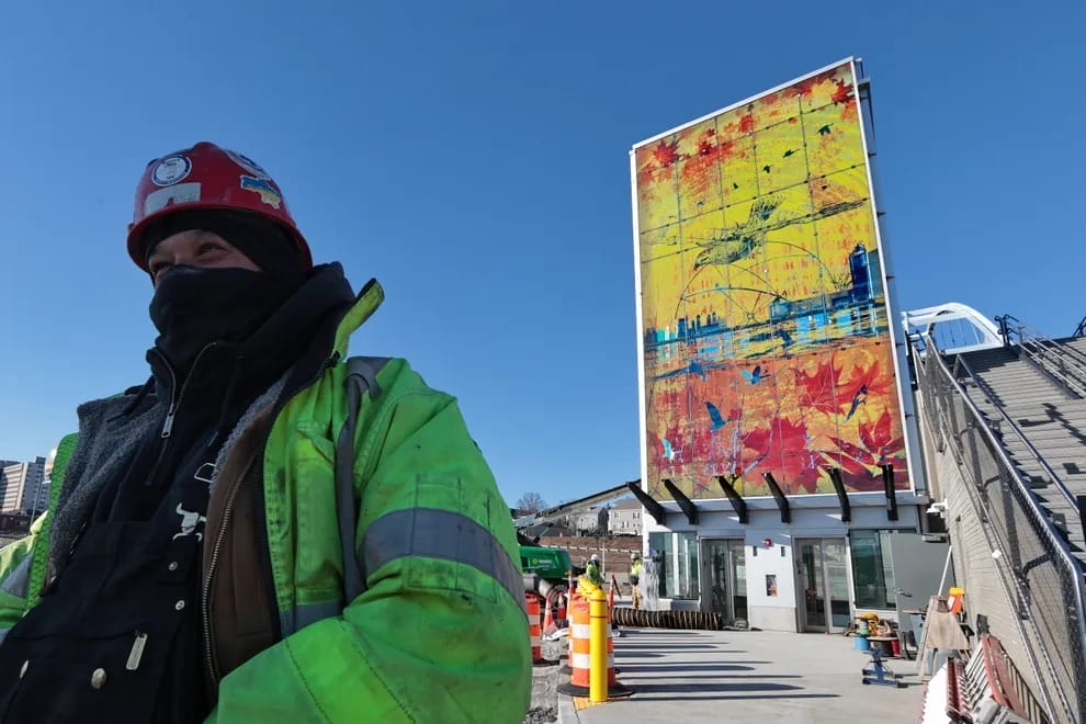 Worker in front of glass installation