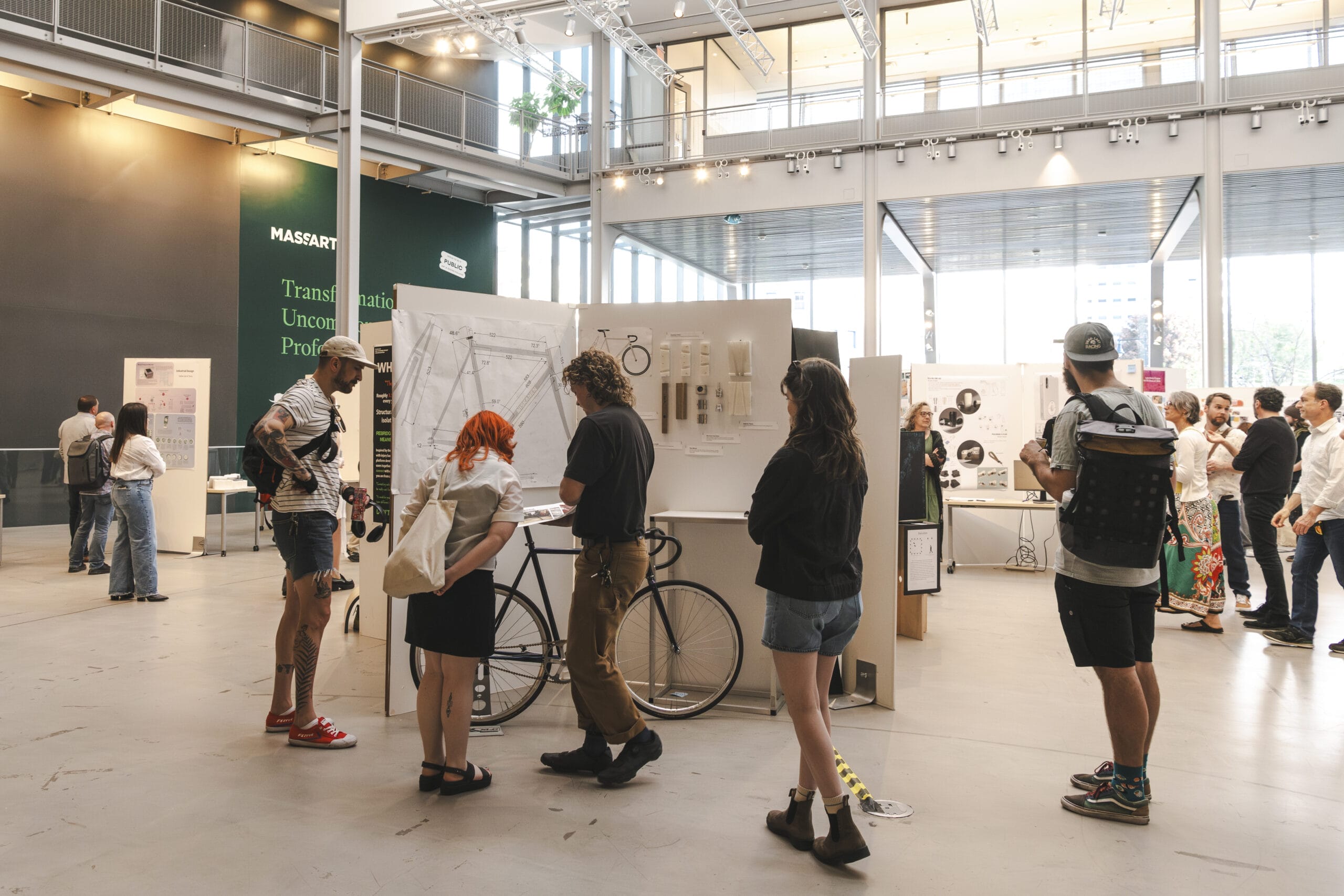 A group of innovation advisors at an art exhibition in a spacious gallery. They are observing a bicycle display and some hanging art pieces. The space is modern and well-lit, with large windows and high ceilings.