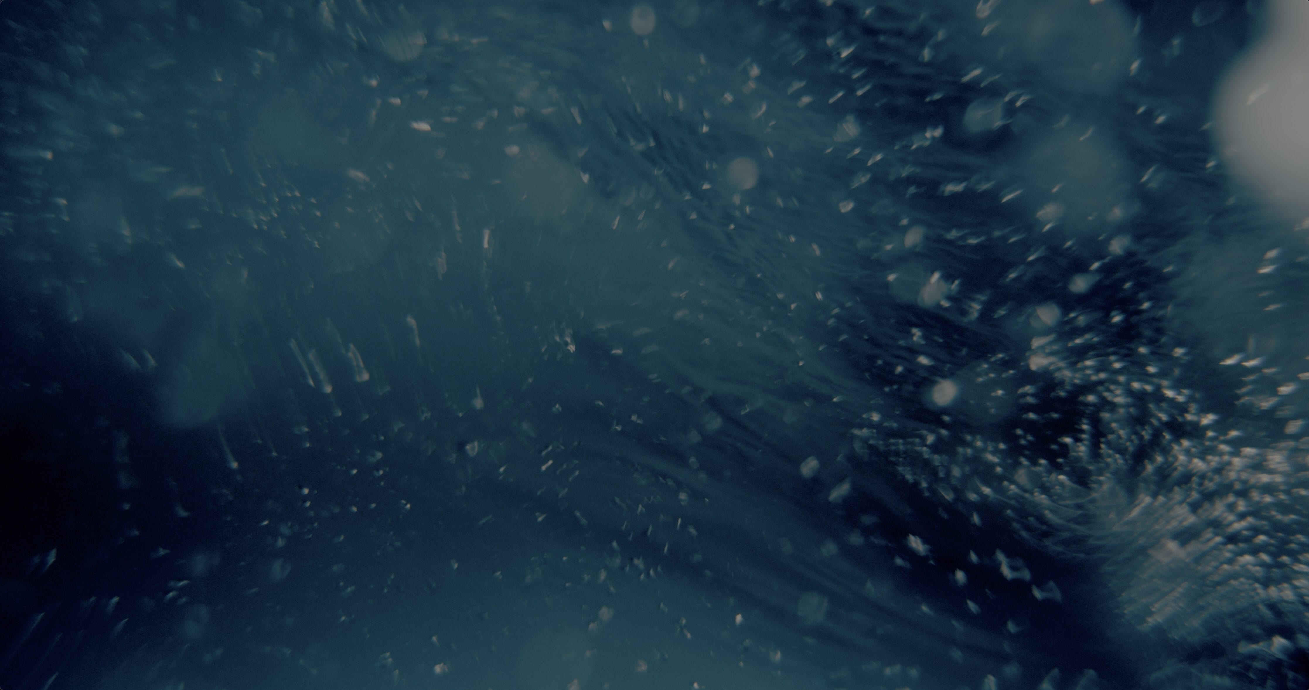 Abstract underwater scene with swirling, dark blue water and floating particles or bubbles, this contemporary vision evokes movement and depth in a mysterious, murky environment—perfect inspiration for public art in New Boston.