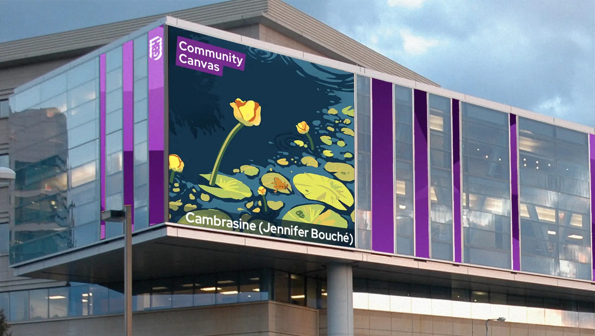 A large building displays a digital art mural of yellow water lilies and green lily pads on a pond. The sign above reads Community Canvas, and below is the artwork’s title and artist, Cambrasine (Jennifer Bouché).