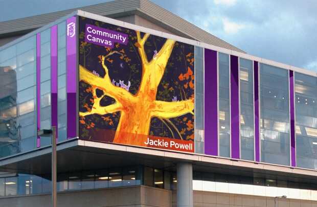 A large digital display on a modern building shows Jackie Powell’s Community Canvas illustration featuring yellow tree branches.